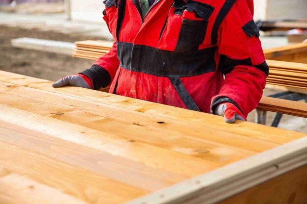 Contractor fastening composite deck boards to a metal frame during a Trex deck installation.