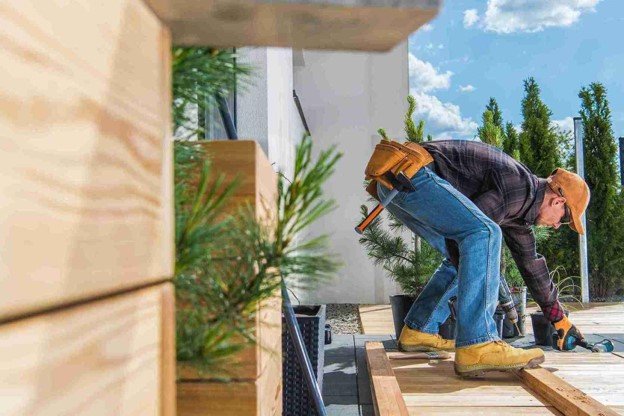A professional on custom deck construction using tool.