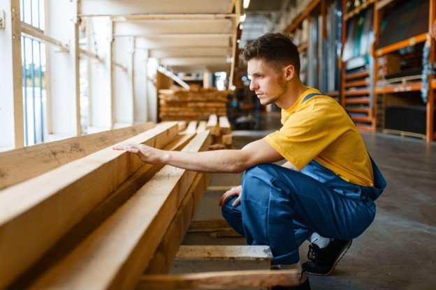 Construction worker inspecting lumber for a custom deck and patio building project